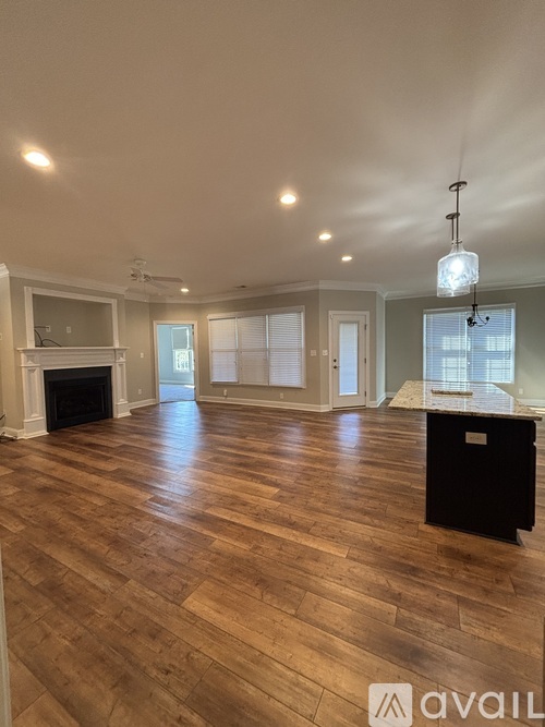 A spacious living room with hardwood floors and a fireplace.