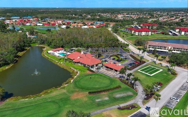 A golf course with a lake and a clubhouse.
