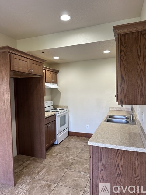 A kitchen with brown cabinets and a tiled floor.