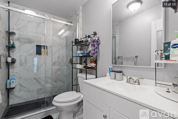 A white bathroom with a toilet, sink, and shower.