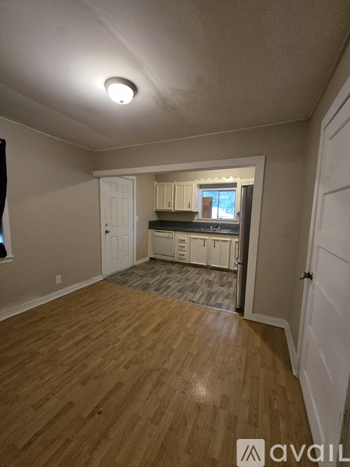 A room with wooden flooring and white walls.