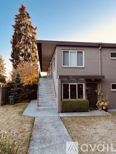 A house with a grey facade and a staircase leading to the entrance.