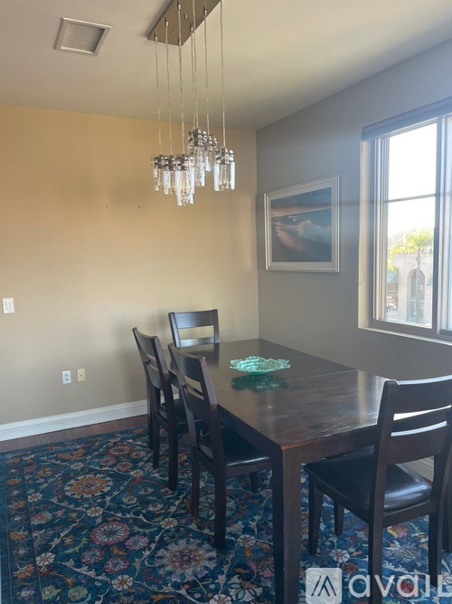 A dining room with a wooden table and chairs.
