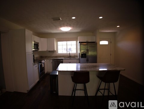 A kitchen with white cabinets and a black countertop.