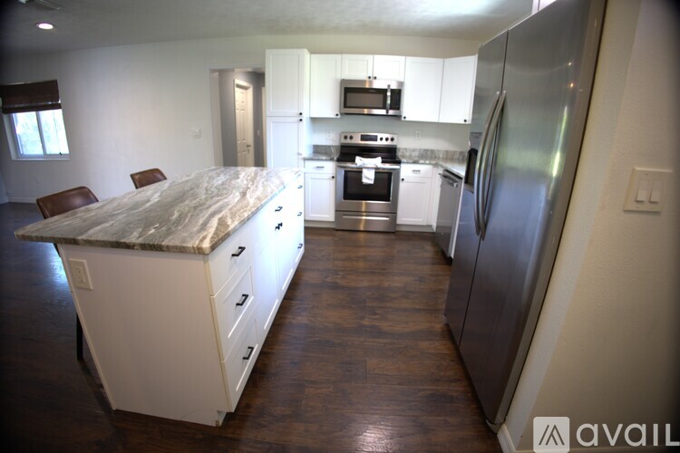 A kitchen with a refrigerator, oven, and microwave.
