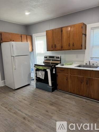 A kitchen with a white fridge and wooden cabinets.