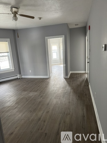 A room with wooden floors and a ceiling fan.