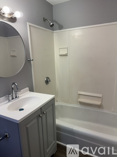 A bathroom with a white sink and a white shower.