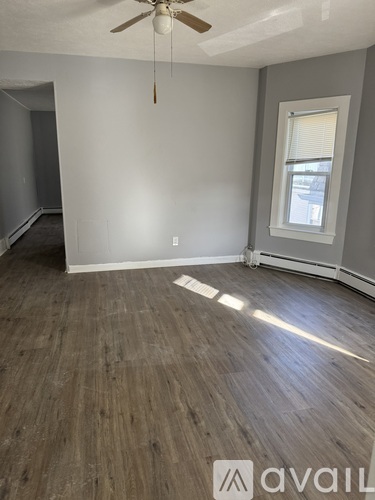 A room with a ceiling fan and a window.