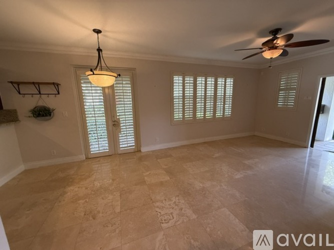 A room with a ceiling fan and a light fixture.
