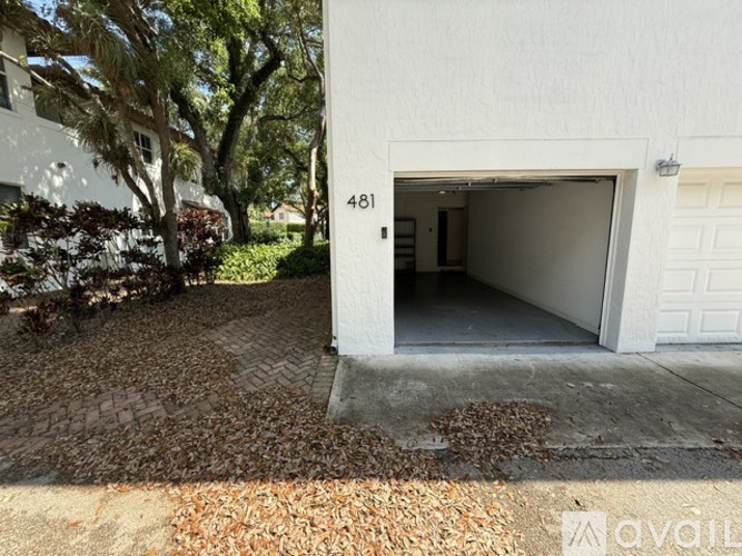 A white garage door is open to reveal a dark interior.