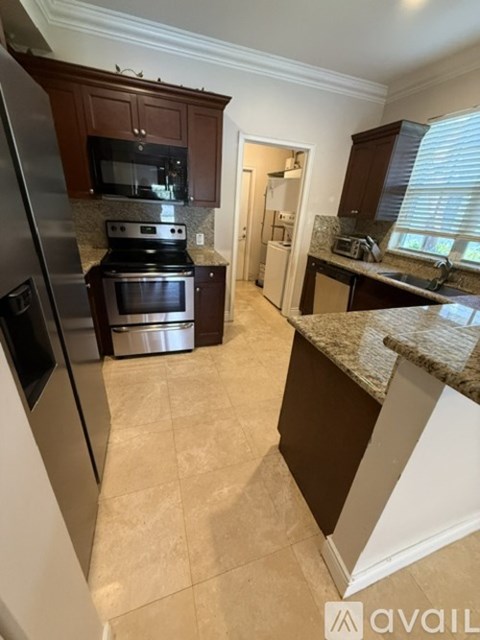 A kitchen with a black stove top oven and a black refrigerator.