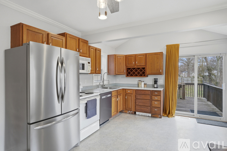 A kitchen with a stainless steel refrigerator and wooden cabinets.
