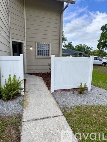 A house with a white fence and a small garden.