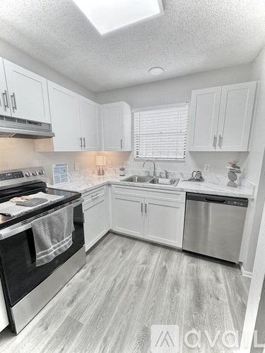 A kitchen with white cabinets and a black stove top oven.