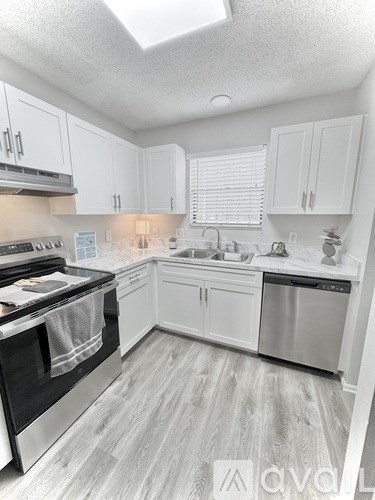 A kitchen with white cabinets and a black stove top oven.