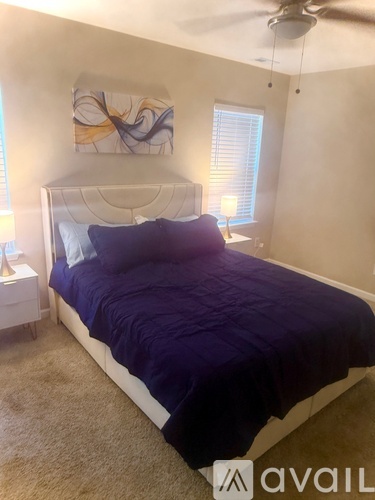 A bedroom with a bed, nightstand, and window.