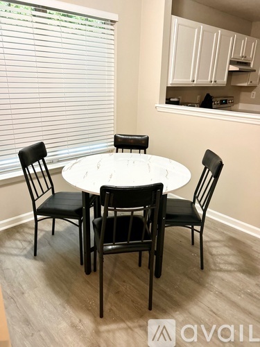 A dining room with a round table and four chairs.