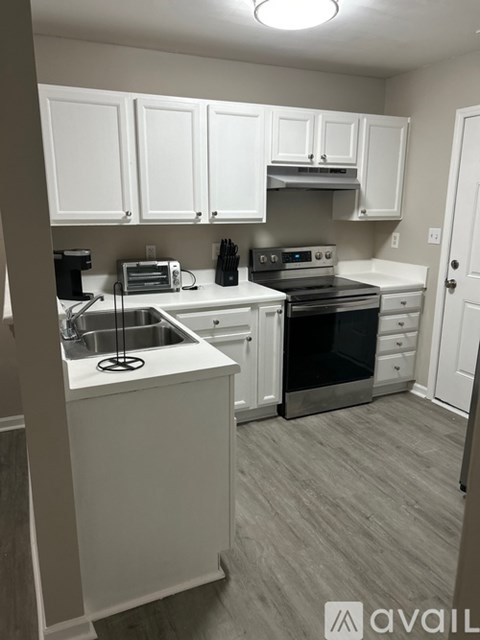 A kitchen with white cabinets and a sink.