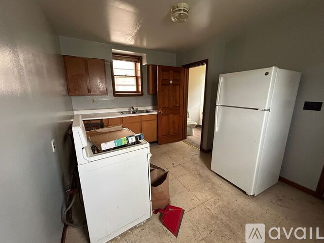 A kitchen with a white fridge and a washing machine.