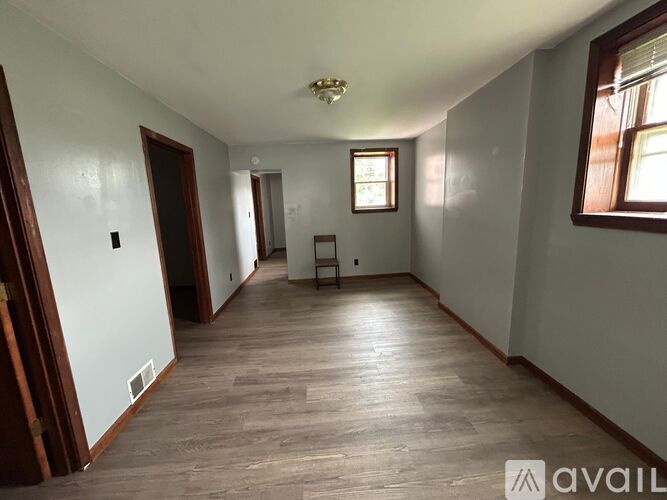 A long, empty room with wooden floors and white walls.