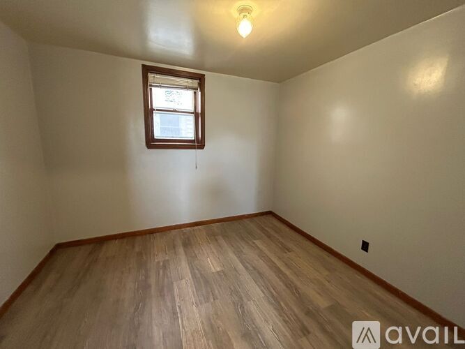 A room with wooden flooring and a window.