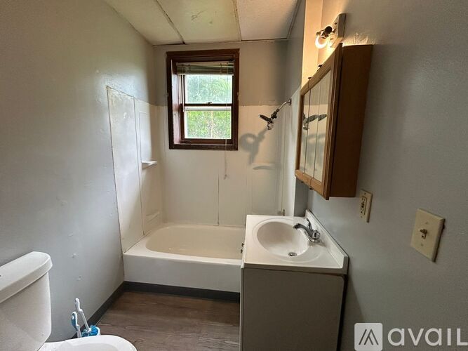 A bathroom with a white tub, sink, and toilet.