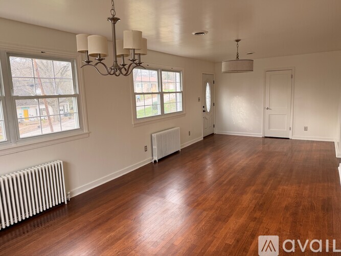 A room with wooden floors and a chandelier.