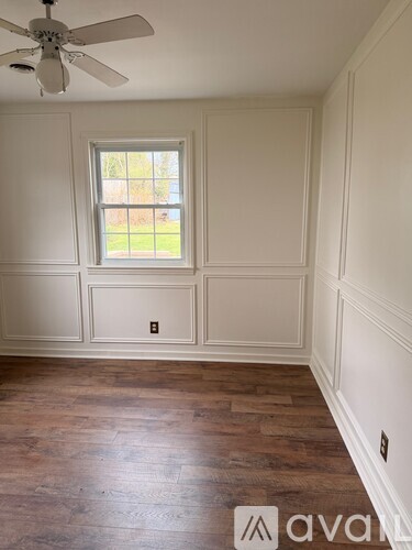A room with a ceiling fan and a window.