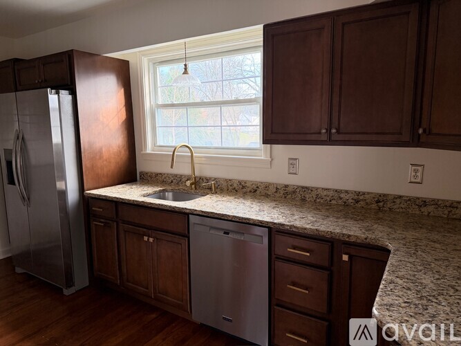 A kitchen with brown cabinets and a granite countertop.