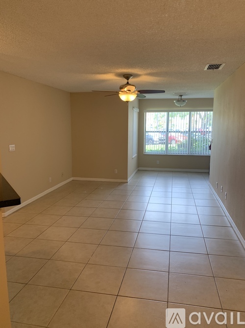 A living room with a tiled floor and a ceiling fan.