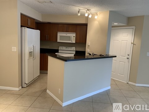 A kitchen with a white refrigerator, microwave, and oven, and a counter with a sink.