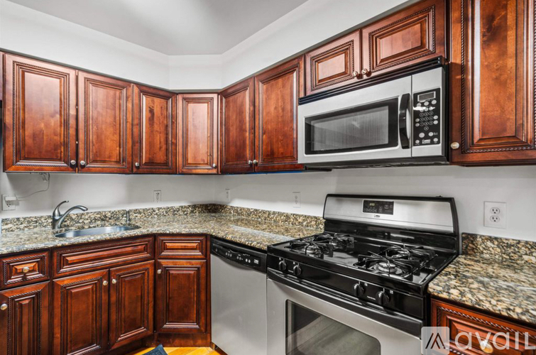A kitchen with wooden cabinets and a black stove top oven.