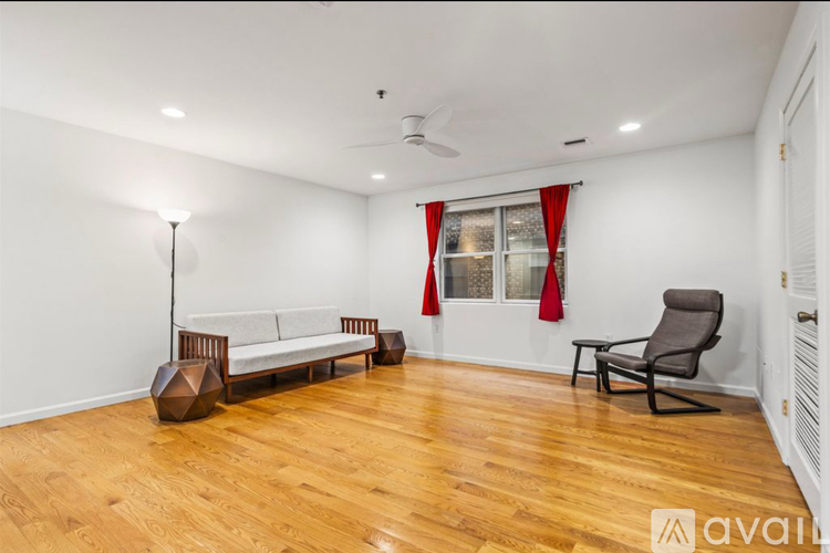 A living room with a white couch, a chair, and a floor lamp.