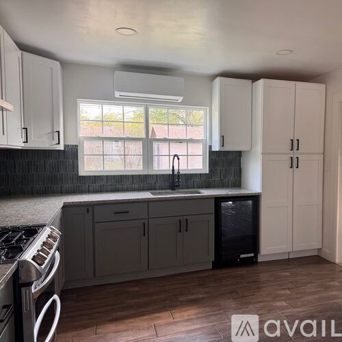 A kitchen with white cabinets and a black fridge.