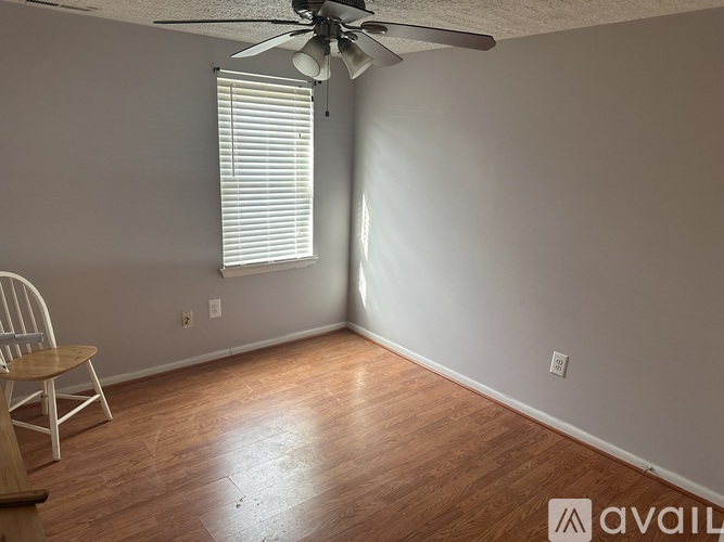 A room with a ceiling fan and a chair.