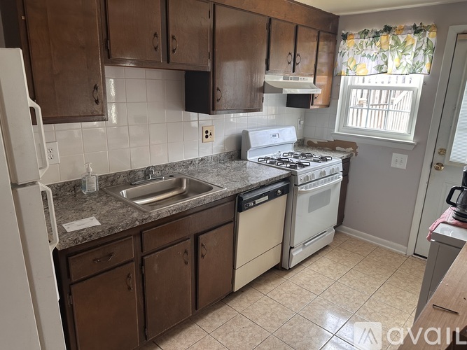 A kitchen with brown cabinets and a white fridge.