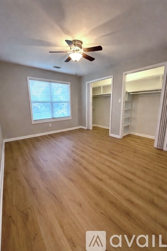 A room with wooden flooring and a ceiling fan.