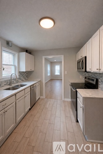 A kitchen with white cabinets and a tiled floor.