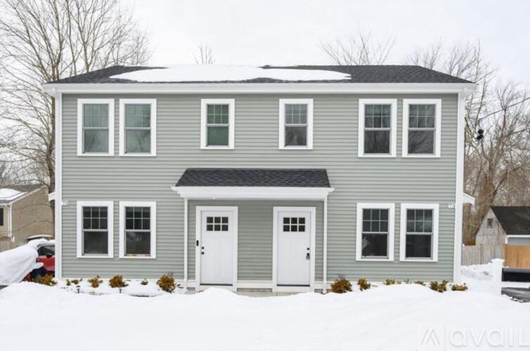 A grey house with a white door and windows.