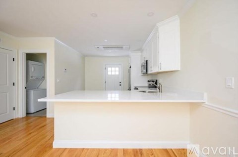 A kitchen with white cabinets and a white island.