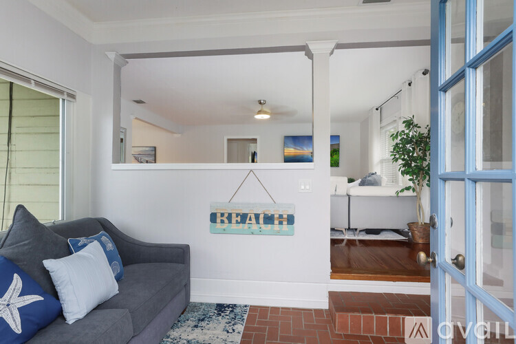 A living room with a grey couch and a blue door.