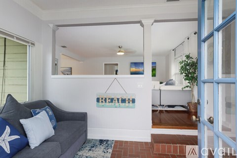 A living room with a grey couch and a blue door.