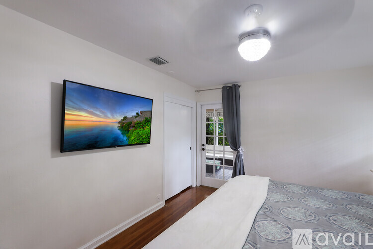 A bedroom with a large bed and a painting on the wall.