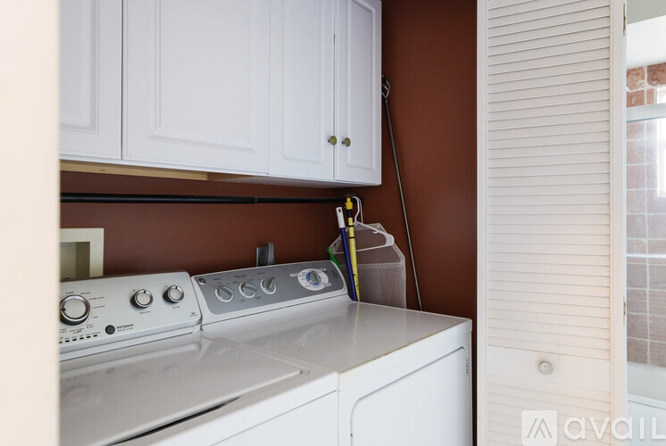 A white dishwasher is in a kitchen with brown walls.