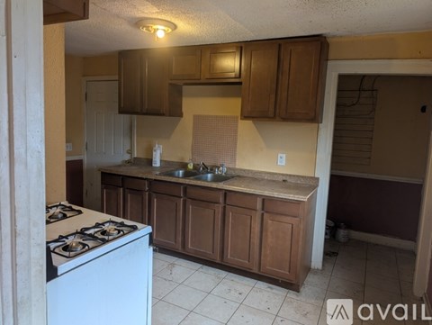 A kitchen with a white stove and brown cabinets.