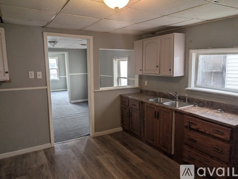 A kitchen with wooden cabinets and a sink under a window.