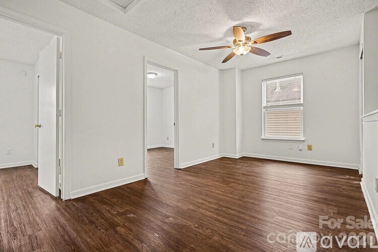 A room with wood flooring and a ceiling fan.