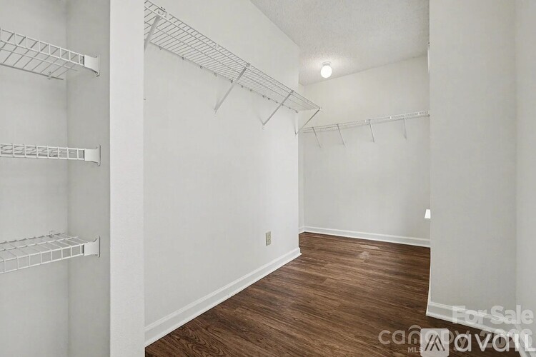 Empty room with white walls and wood flooring.
