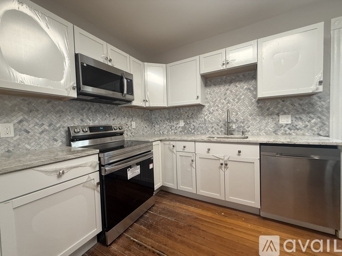 A kitchen with white cabinets and a black oven.